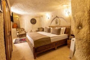 Un dormitorio con una cama en una habitación de piedra. en Arkelas Cave House, en Göreme