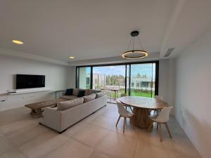 un soggiorno con un divano e un tavolo di Spacious Beach House in Malaga-Cala de Mijas, amazing see view, 3 bedroom, garden & Common Pool a Málaga