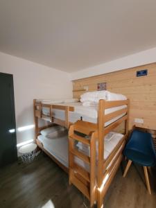 ein Zimmer mit zwei Etagenbetten und einem blauen Stuhl in der Unterkunft Studio avec balcon sud LES PISTEURS in Le Dévoluy