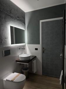 a bathroom with a toilet and a sink and a mirror at Villa Riviera Hotel Udine in Pradamano +26 photos