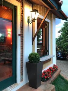 a front door of a house with a potted plant at Hotel Chalés Gramado in Santa Bárbara do Rio Pardo