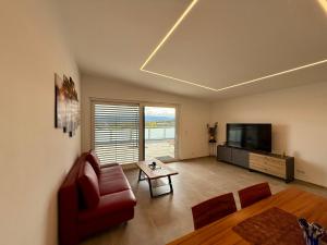 een woonkamer met een bank en een televisie bij Mc Home Neues und sonniges Doppelhaus, Top 1 mit grosse Terrasse und E-Ladestation in Dobl bei Graz in Dobl