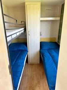 2 Etagenbetten in einem Zimmer mit blauen Kissen in der Unterkunft Mobilheim Na louce III in Výrovice