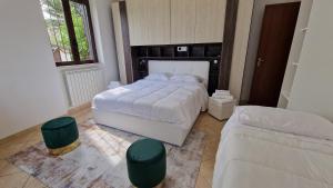 a bedroom with a bed and two ottomans at Country Chic Antico Casale - piscina idromassaggio lettini, solarium, cinema experience, wifi, parcheggio in Caiazzo