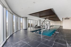 メルボルンにあるGorgeous High-Rise Unit with Sky Bar Pool and Gymの窓のある建物内の屋内プール