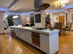 a kitchen with a stove and a living room at Villa Rose in Sheikh Zayed