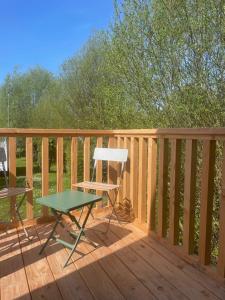 una terraza de madera con una mesa y una silla. en La CABANE PERCHÉE, en Saint-Valery-sur-Somme 2 fotos más