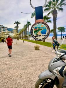 a sign for a viva wae on a sidewalk at Vlora Vibe in Vlorë