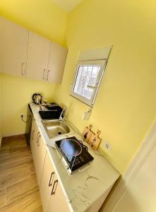 a small kitchen with a sink and a window at Vlora Vibe in Vlorë