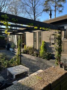 a small house with a bench in front of it at Quiet and spacious holiday home in Voorthuizen