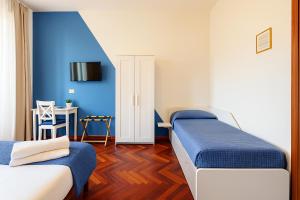 a bedroom with two beds and a blue wall at City Love Rooms in Siracusa +27 photos