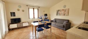 a living room with a table and a couch at Casa Nala - Villa con giardino in Budoni
