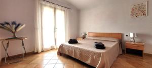 a bedroom with a bed with two black towels on it at Casa Nala - Villa con giardino in Budoni +4 photos