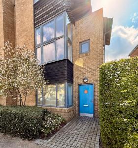 a brick house with a blue door at Spacious 4 Bedroom Townhouse in Essex in Burnt Mill