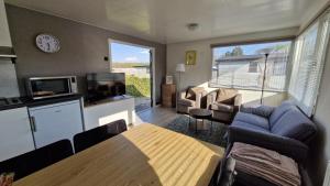 a living room with a dining table and a kitchen at Chalet 'Forest Happiness' in Anloo