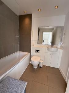 a bathroom with a toilet and a tub and a sink at Spacious 4 Bedroom Townhouse in Essex in Burnt Mill +4 photos