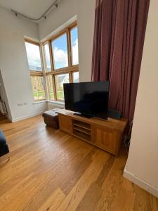 a living room with a flat screen tv on a table at Spacious 4 Bedroom Townhouse in Essex in Burnt Mill