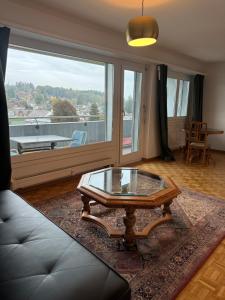 KönizSchöne Wohnung in Bern的客厅设有咖啡桌和大窗户