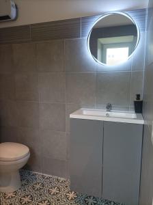 Un baño con inodoro, lavabo y espejo. en Love Room, L'aubertine, en Putanges
