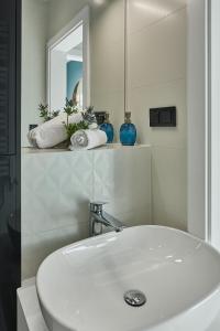 a bathroom with a white sink and a mirror at CREST VIEW 777th - SPA & Seaview Apartment in Międzyzdroje