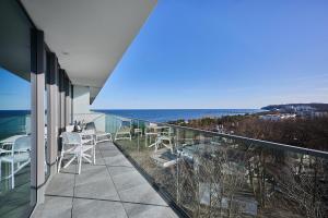 a balcony with chairs and a view of the ocean at CREST VIEW 777th - SPA & Seaview Apartment in Międzyzdroje