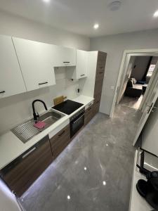 a kitchen with white cabinets and a sink at Stylish Home Theater Apartment 3 in Kreuztal +5 photos