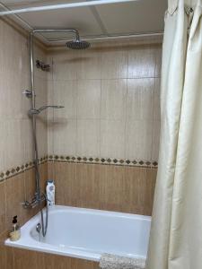 a bathroom with a bath tub with a shower curtain at Pura Vida in Águilas