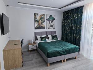 ein Schlafzimmer mit einem Bett mit einer grünen Decke in der Unterkunft Pensjonat-ek pod Jaworem in Hajnówka + 27 Fotos