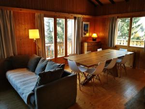 a living room with a couch and a table with chairs at Chalet St-Hubert in Les Collons