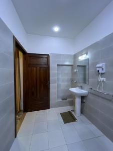 a bathroom with a sink and a wooden door at Riad Fes Miracle in Fès al Bali
