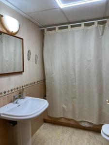 a bathroom with a sink and a shower curtain at Pura Vida in Águilas +11 photos