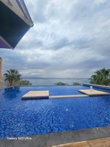 a large swimming pool with a view of the ocean at E01 Samarah Resort One Bedroom apartment in Sowayma