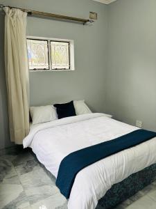 a large bed in a bedroom with a window at Mpande - The Roots Your Home Away from Home in Bulawayo +13 photos