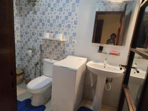 a bathroom with a white toilet and a sink at Keur Aïda Immeuble de standing in Dakar +14 photos