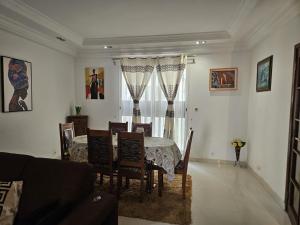 a living room with a dining room table and chairs at Keur Aïda Immeuble de standing in Dakar