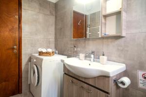 a bathroom with a sink and a washing machine at Fotini's House Tsagarada Pelion in Tsagarada +13 photos