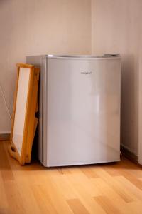a refrigerator sitting on a wooden floor next to a wall at Charmante 2 Zimmer plus Bad und Balkon ohne Küche in Niestetal
