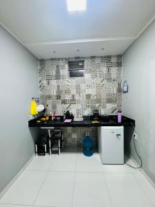 a kitchen with a black counter and a tile wall at Aconchego da Serra ibiapaba in Ipu +12 photos