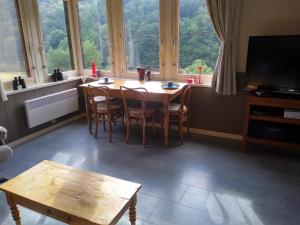 a dining room with a table and chairs and windows at Le silence de Frahan in Bouillon