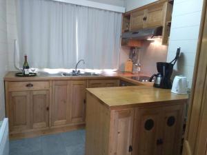 a kitchen with wooden cabinets and a sink at Le silence de Frahan in Bouillon +16 photos