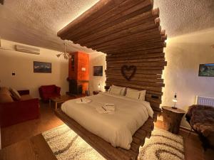 a bedroom with a large bed with a wooden wall at 4 MOUNTAIN HILLS in Megalo Chorio