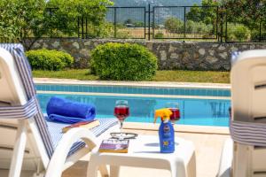 a table with two glasses of wine on it next to a pool at Villa Gelincik in Kas