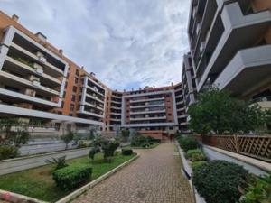 a large apartment building with a garden in front of it at Moonlight Apartment in Fiumicino