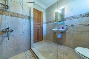a bathroom with a shower and a toilet and a sink at Villa Gelincik in Kas +3 photos