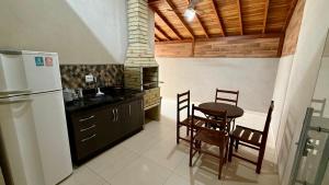 Il comprend une cuisine équipée d'un réfrigérateur, d'une table et de chaises. dans l'établissement Casa Região Central, à Olímpia