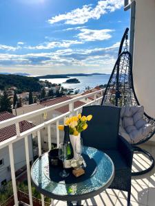 a balcony with a blue chair and a table with flowers at B&B Buzolic 1 Hvar in Hvar