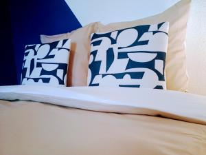 ein Bett mit blauen und weißen Kissen darauf in der Unterkunft Studio Beau Soleil in LʼIsle-sur-la-Sorgue