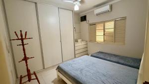 une petite chambre avec un lit et une fenêtre dans l'établissement Casa Região Central, à Olímpia