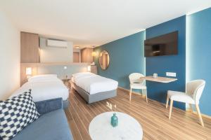 a hotel room with two beds and a table at Hotel-Restaurant Seegarten-Marina in Spiez +64 photos