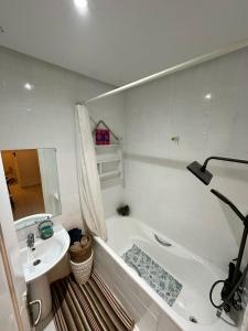 a white bathroom with a sink and a tub and a toilet at Corniche la Marsa in Douar el Hafey +70 photos
